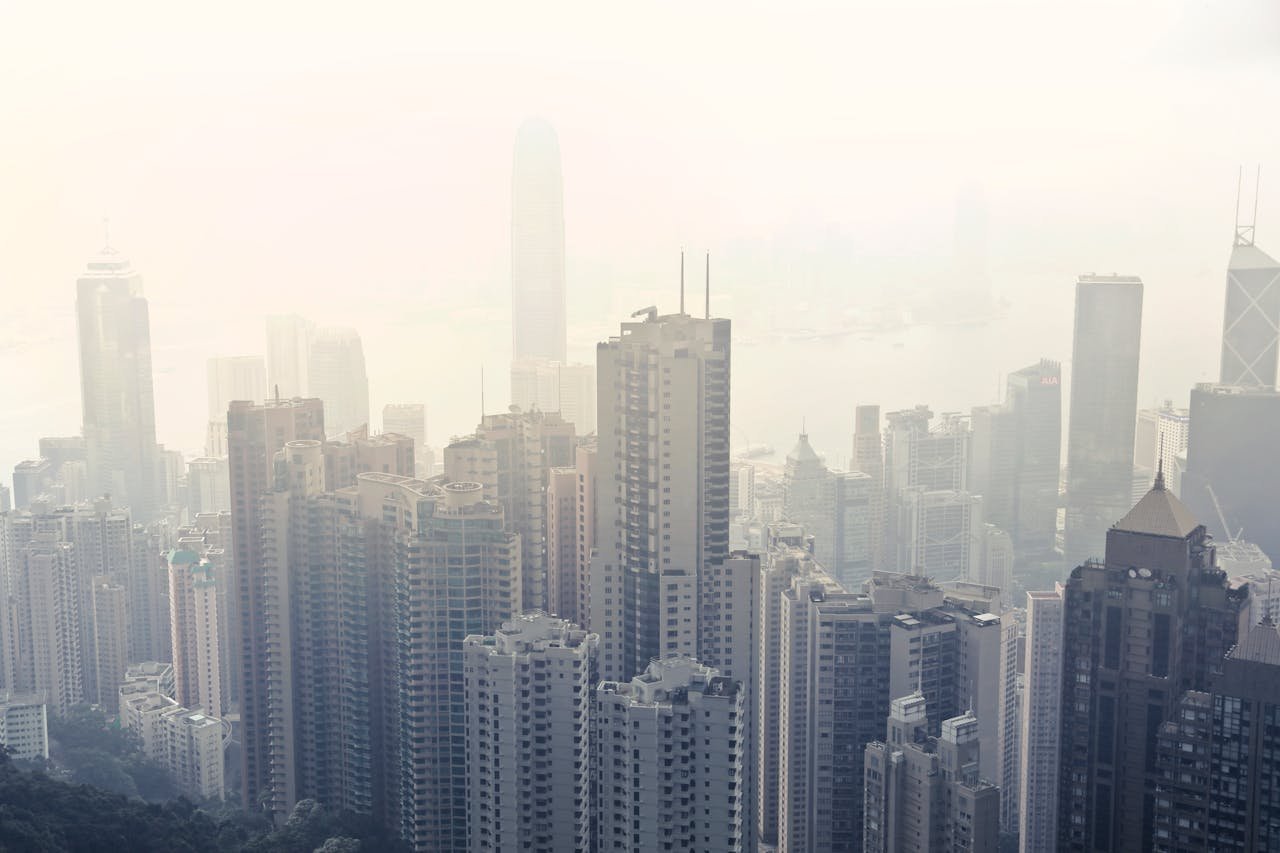 A foggy view of Hong Kong Island's skyline, featuring numerous skyscrapers and urban architecture.