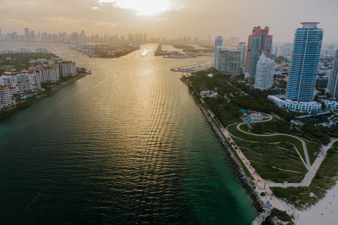 Stunning aerial view of Miami skyline and ocean at sunset, capturing urban and natural beauty.